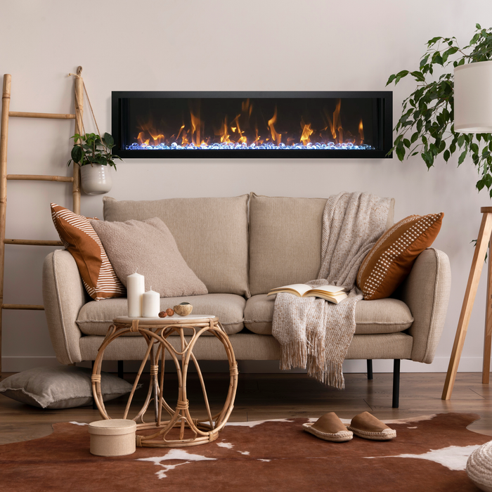 Amantii linear built-in electric fireplace installed flush in a warm boho living room wall, above a beige sofa with plants and rattan decor