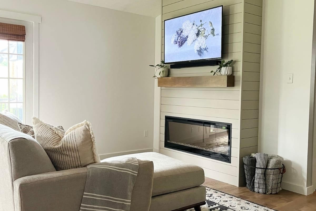 Simple living room with shiplap bump out and recessed linear electric fireplace below a wall-mounted TV