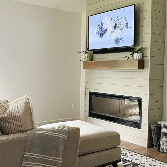 Simple living room with shiplap bump out and recessed linear electric fireplace below a wall-mounted TV