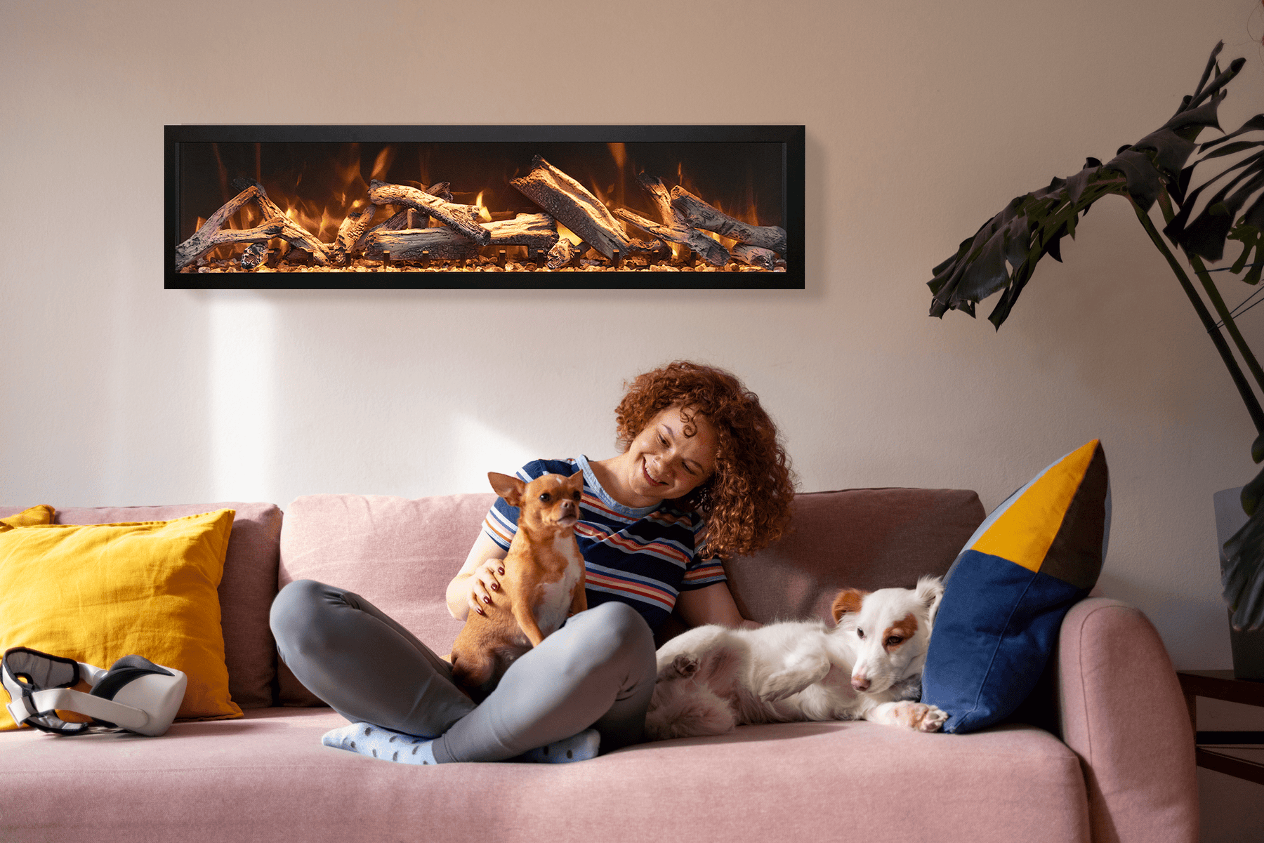 Remii DEEP electric fireplace installed in a living room with a woman and two dogs on the sofa